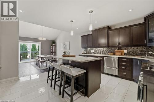 Open-concept kitchen with dark wood cabinetry, stainless steel appliances, and a mosaic tile backsplash - 7 Gibson Place Unit# 26, St. Catharines, ON - Indoor Photo Showing Kitchen With Upgraded Kitchen