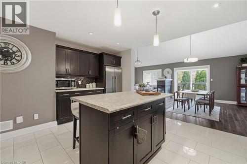 Kitchen island with a light-toned countertop and dark wood-finish cabinetry - 7 Gibson Place Unit# 26, St. Catharines, ON - Indoor Photo Showing Kitchen With Upgraded Kitchen