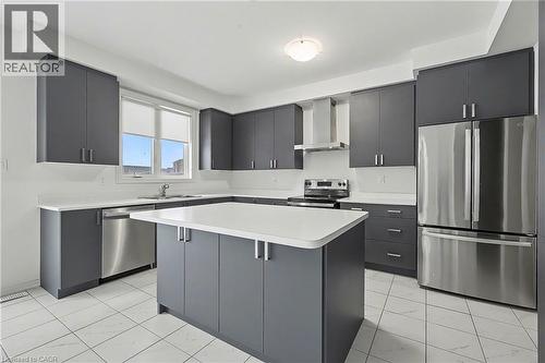 Modern kitchen featuring dark grey cabinetry with silver hardware, white countertops, stainless steel appliances, and white tile flooring - 123 Rea Drive, Fergus, ON - Indoor Photo Showing Kitchen With Upgraded Kitchen