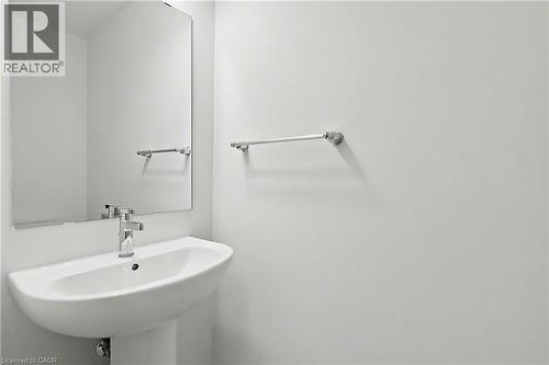 Pedestal sink with a polished chrome faucet and matching towel bar, complemented by a wall-mounted mirror - 123 Rea Drive, Fergus, ON - Indoor Photo Showing Bathroom