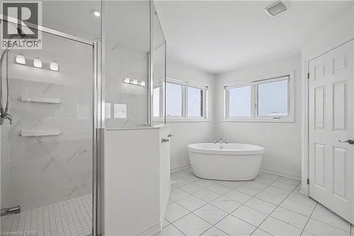Freestanding soaking tub and glass-enclosed shower with tiled walls - 123 Rea Drive, Fergus, ON - Indoor Photo Showing Bathroom