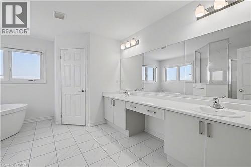 Spacious bathroom featuring a double vanity with ample counter space, dual undermount sinks, and an expansive wall-mounted mirror - 123 Rea Drive, Fergus, ON - Indoor Photo Showing Bathroom