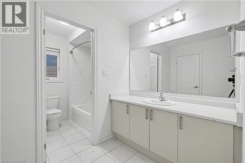 Bathroom featuring a vanity with an integrated sink, a large mirror, and a three-light fixture - 123 Rea Drive, Fergus, ON - Indoor Photo Showing Bathroom