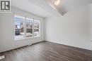 Spacious interior featuring a large multi-pane window, wood-finish flooring, white walls, and a semi-flush mount ceiling light - 123 Rea Drive, Fergus, ON  - Indoor Photo Showing Other Room 
