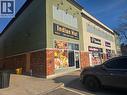 Commercial storefront featuring a brick lower facade and light green upper siding - 4322 Ontario Street Unit# 1, Lincoln, ON 