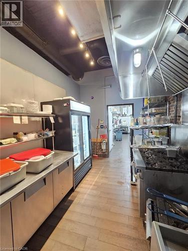 Commercial kitchen featuring wood-finish flooring, stainless steel appliances, and exposed ceiling ductwork - 4322 Ontario Street Unit# 1, Lincoln, ON 