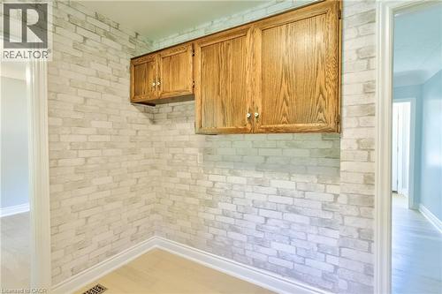 Wall-mounted cabinetry with wood-finish doors and brushed nickel hardware - 31 Brodick Street, Hamilton, ON - Indoor Photo Showing Other Room