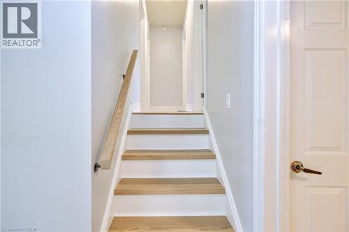 Staircase featuring wood-finish treads, white risers, and a natural wood handrail - 31 Brodick Street, Hamilton, ON - Indoor Photo Showing Other Room