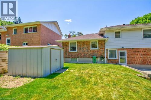 Expansive rear yard featuring a large storage shed on a concrete base, a sloped lawn, and a retaining wall - 31 Brodick Street, Hamilton, ON - Outdoor With Exterior