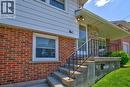 Front entrance featuring concrete steps with a black metal handrail, leading to a covered porch with stone-veneer siding - 31 Brodick Street, Hamilton, ON  - Outdoor With Exterior 