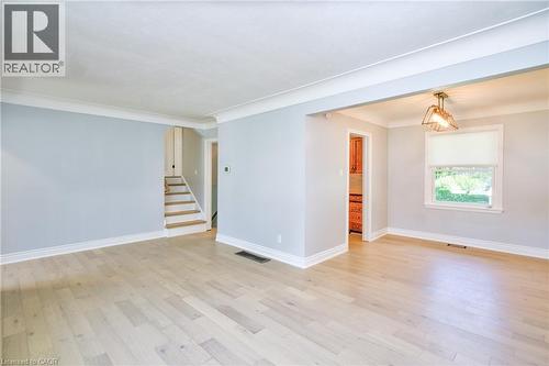 Spacious room featuring light wood-finish flooring, light gray walls, and white crown molding - 31 Brodick Street, Hamilton, ON - Indoor Photo Showing Other Room