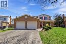 Brick and siding exterior featuring a two-car garage with white doors, a paved driveway, and a covered front porch with a red entry door - 113 Glenecho Court, Waterloo, ON  - Outdoor With Facade 