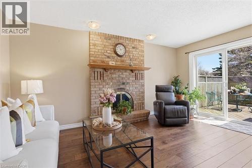 Interior space featuring wood-finish flooring and a brick fireplace with a wood mantle - 113 Glenecho Court, Waterloo, ON - Indoor Photo Showing Living Room With Fireplace