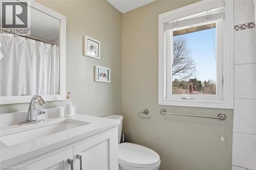 Full bathroom featuring a white single vanity with integrated sink, chrome faucet, framed mirror, and a window for natural light - 113 Glenecho Court, Waterloo, ON - Indoor Photo Showing Bathroom