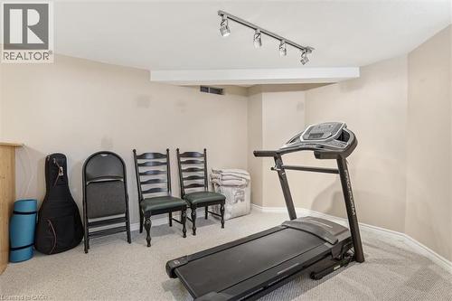 Carpeted room with track lighting, neutral wall paint, and white trim - 113 Glenecho Court, Waterloo, ON - Indoor Photo Showing Gym Room