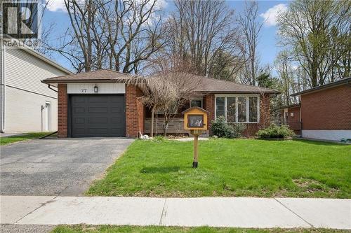 Brick exterior with a prominent single-car garage featuring a dark panel door - 27 Silverspring Crescent, Kitchener, ON - Outdoor