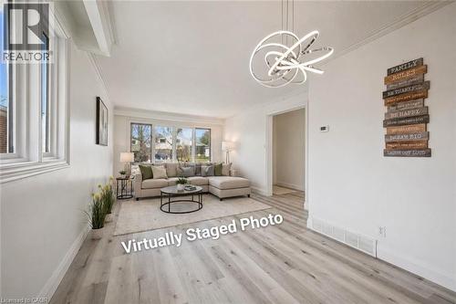 Bright living area featuring light wood-finish flooring, white baseboards, and white crown molding - 27 Silverspring Crescent, Kitchener, ON - Indoor