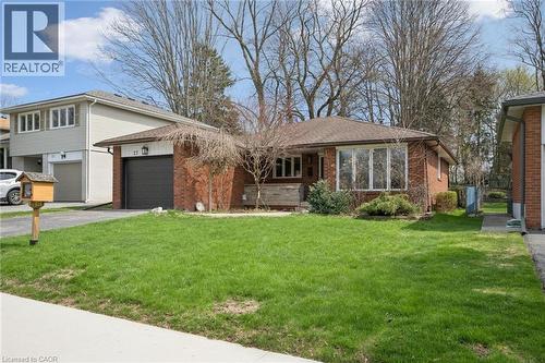 Brick exterior featuring a single-car garage with a dark door - 27 Silverspring Crescent, Kitchener, ON - Outdoor