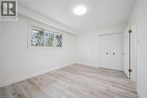 Bright interior space featuring light wood-finish flooring, white baseboards, and a contemporary flush-mount ceiling light - 27 Silverspring Crescent, Kitchener, ON - Indoor Photo Showing Other Room