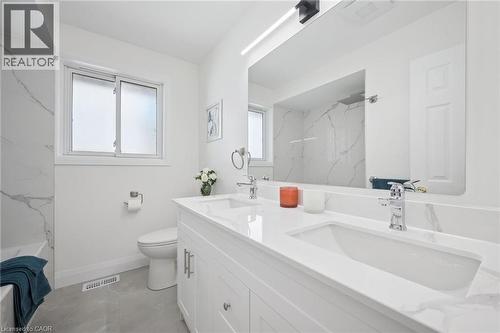 Dual vanity with integrated sinks and a large wall-mounted mirror - 27 Silverspring Crescent, Kitchener, ON - Indoor Photo Showing Bathroom