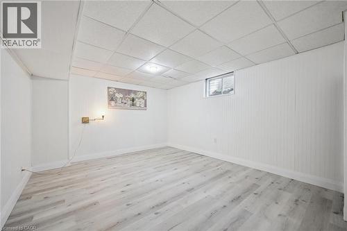 Spacious room featuring light wood-finish flooring, white paneled walls, a drop ceiling with recessed lighting, and a window with blinds - 27 Silverspring Crescent, Kitchener, ON - Indoor Photo Showing Other Room