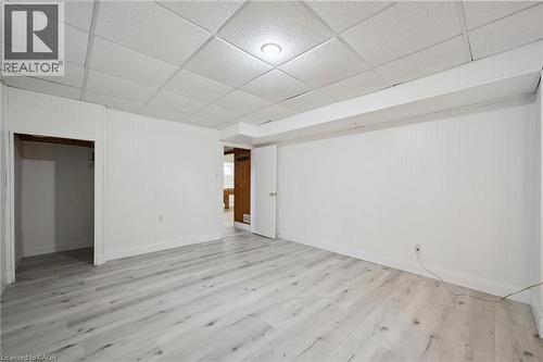 Spacious room featuring light wood-finish flooring, white paneled walls, and a white drop ceiling with recessed lighting - 27 Silverspring Crescent, Kitchener, ON - Indoor Photo Showing Other Room