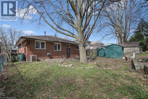 Brick exterior residence featuring multiple windows, a rear entry door, and a prominent mature tree - 27 Silverspring Crescent, Kitchener, ON - Outdoor