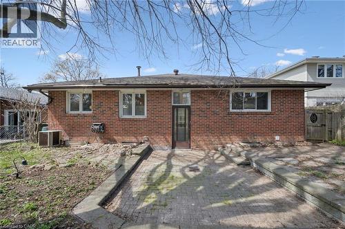 Brick exterior with multiple windows and a central glass-paneled door - 27 Silverspring Crescent, Kitchener, ON - Outdoor