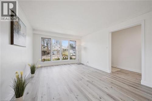 Bright interior space featuring light wood-finish flooring, white walls, and extensive crown molding - 27 Silverspring Crescent, Kitchener, ON - Indoor