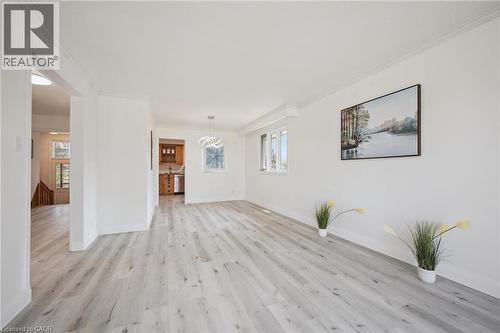 Open living area featuring light wood-finish flooring, white walls, and crown molding - 27 Silverspring Crescent, Kitchener, ON - Indoor
