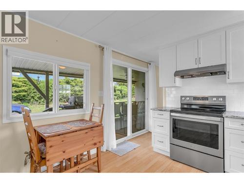 View of kitchen with the entry door and deck in the background. Eating nook with a great view of the yard. - 12022 Pretty Road Unit# 16, Lake Country, BC 