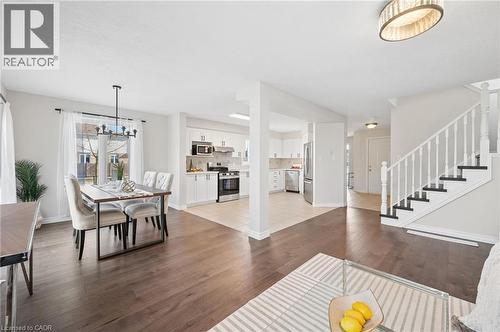 Dining area with dark wood-style floors and a chandelier - 649 Doon South Drive, Kitchener, ON - Indoor