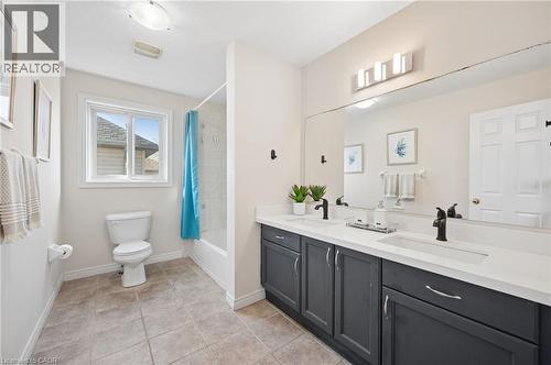 Bathroom with double vanity, shower / tub combo, and light tile patterned flooring - 649 Doon South Drive, Kitchener, ON - Indoor Photo Showing Bathroom
