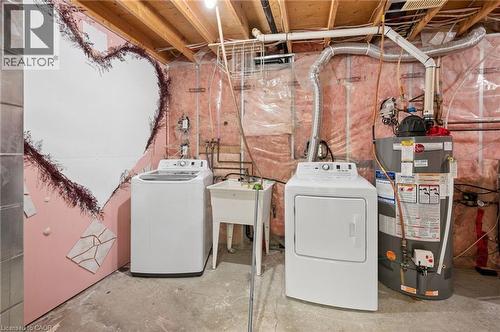 Laundry area featuring concrete flooring, washer and dryer, and gas water heater - 649 Doon South Drive, Kitchener, ON - Indoor Photo Showing Laundry Room
