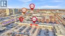 Aerial view highlighting the commercial district with multiple retail establishments, extensive parking areas, and adjacent multi-story residential buildings - 589 Fairway Road S, Kitchener, ON 