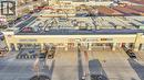 Commercial retail building featuring multiple storefronts, a prominent sign structure, and an expansive paved parking area - 589 Fairway Road S, Kitchener, ON 