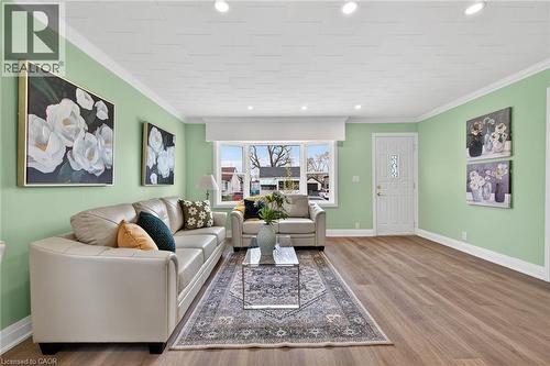 Spacious living area featuring wood-finish flooring, recessed lighting, and crown molding - 36 Mahony Avenue, Hamilton, ON - Indoor Photo Showing Living Room
