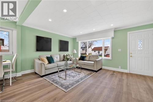 Open-concept living space featuring wood-finish flooring, recessed lighting, and a front entry door with decorative glass inserts - 36 Mahony Avenue, Hamilton, ON - Indoor Photo Showing Living Room
