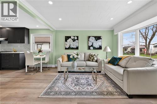 Open-concept living area featuring wood-finish flooring, recessed lighting, and a bay window - 36 Mahony Avenue, Hamilton, ON - Indoor Photo Showing Living Room