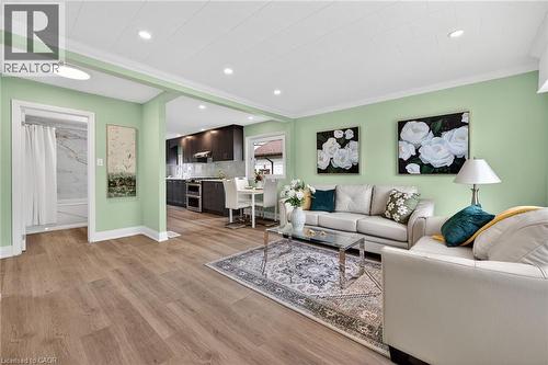 Open-concept living area featuring wood-finish flooring and light green walls - 36 Mahony Avenue, Hamilton, ON - Indoor Photo Showing Living Room