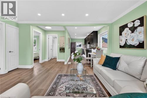 Open-concept living area featuring wood-finish flooring, recessed lighting, and light green wall finishes - 36 Mahony Avenue, Hamilton, ON - Indoor Photo Showing Living Room