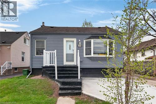 Exterior featuring gray horizontal siding, a dark shingle roof, and a bay window - 36 Mahony Avenue, Hamilton, ON - Outdoor