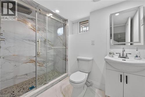 Modern bathroom featuring a glass-enclosed shower with marbled wall tile and pebble flooring - 36 Mahony Avenue, Hamilton, ON - Indoor Photo Showing Bathroom