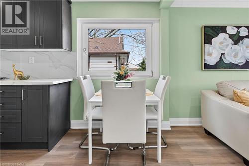 Compact dining area featuring wood-finish flooring and light green walls - 36 Mahony Avenue, Hamilton, ON - Indoor Photo Showing Dining Room