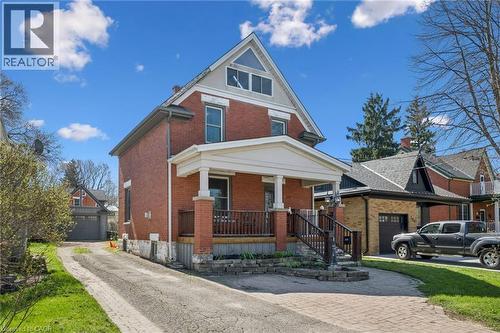 Brick exterior featuring a covered front porch with pillars, a gabled roofline, and multiple window styles - 115 Allen Street E, Waterloo, ON - Outdoor With Facade