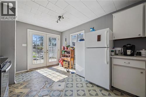 Double French doors leading to the exterior, with patterned floor tiles, white upper and lower cabinetry, and horizontal wall paneling - 115 Allen Street E, Waterloo, ON - Indoor Photo Showing Kitchen