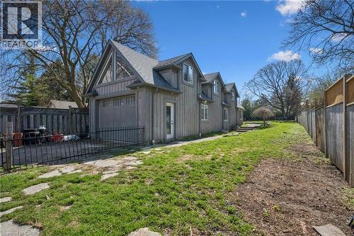 Rear exterior featuring vertical siding, multiple dormer windows, and a detached garage with an A-frame gable - 115 Allen Street E, Waterloo, ON - Outdoor