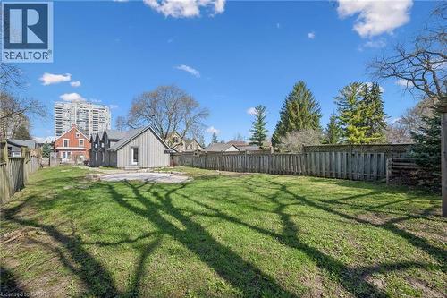 Expansive grassy yard with wood fencing and mature trees - 115 Allen Street E, Waterloo, ON - Outdoor With Backyard