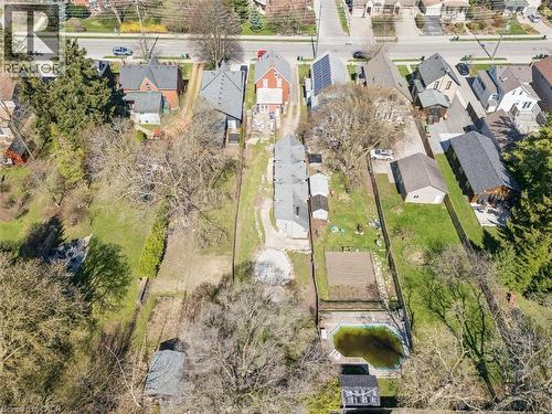 Aerial perspective showcasing multiple residential properties, expansive green spaces, mature trees, and a private pool structure - 115 Allen Street E, Waterloo, ON - Outdoor With View