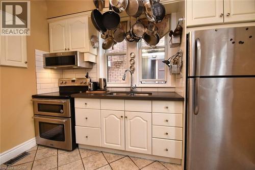 Kitchen featuring cream cabinetry, stainless steel appliances, a double oven, and a double-basin sink - 522 Aberdeen Avenue, Hamilton, ON - Indoor Photo Showing Kitchen With Double Sink